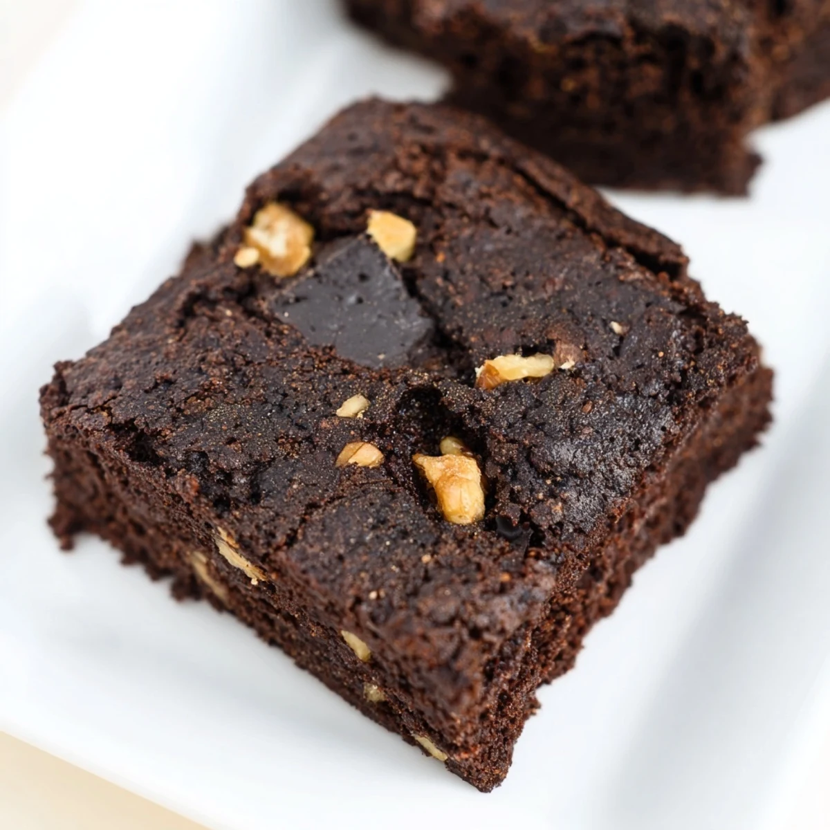 Golden-brown gluten-free almond flour brownies cooling on a wire rack, showing a fudgy center and crackly top.  