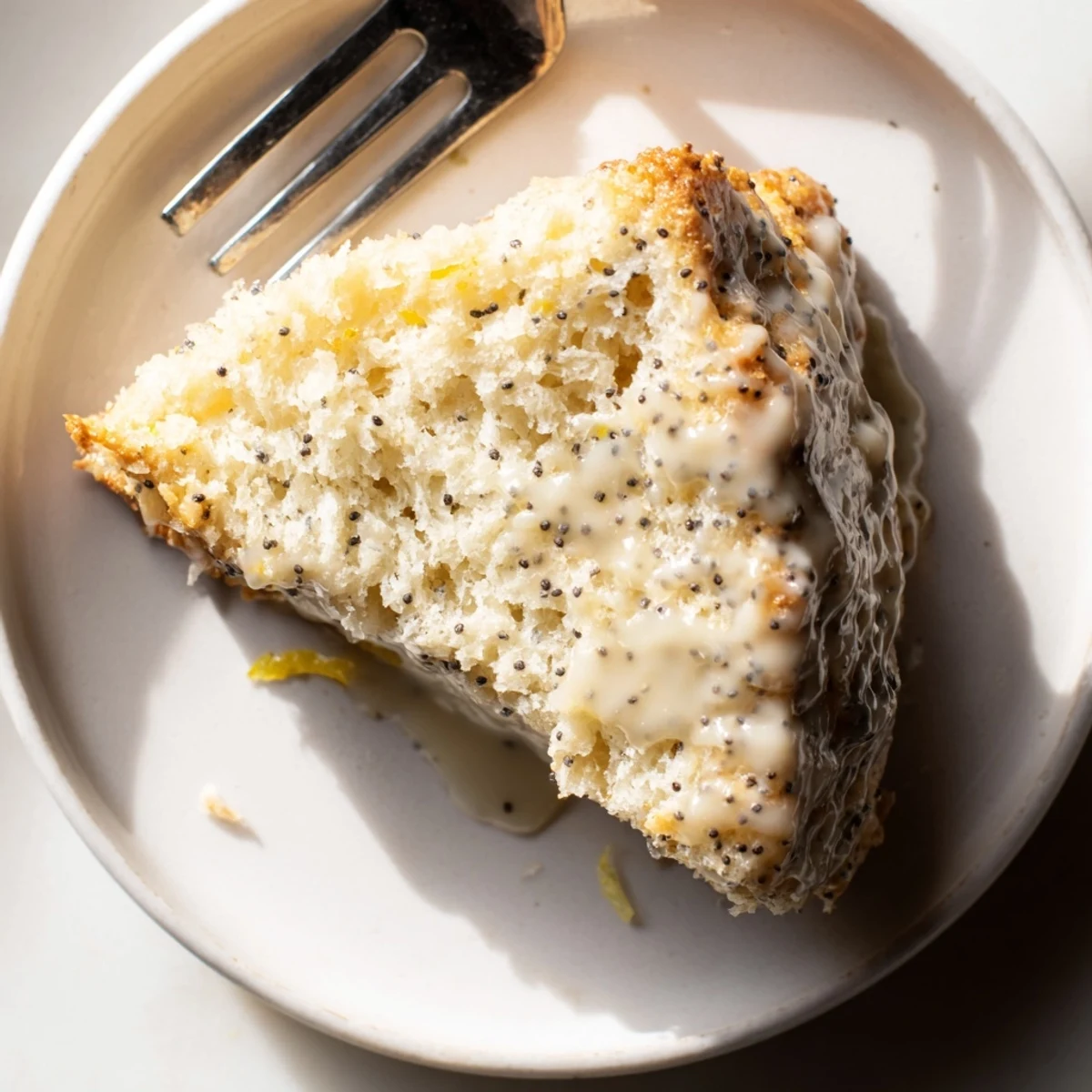 Freshly baked Lemon Poppy Seed Scones with a sweet lemon glaze on a rustic wooden board.
