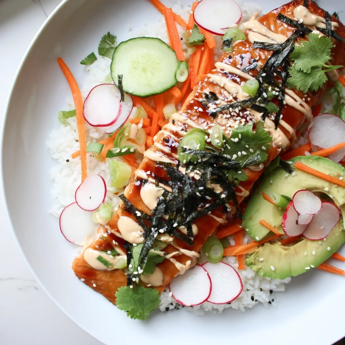 Savory teriyaki salmon rice taco bowls drizzled with spicy mayo and topped with sliced avocado.
