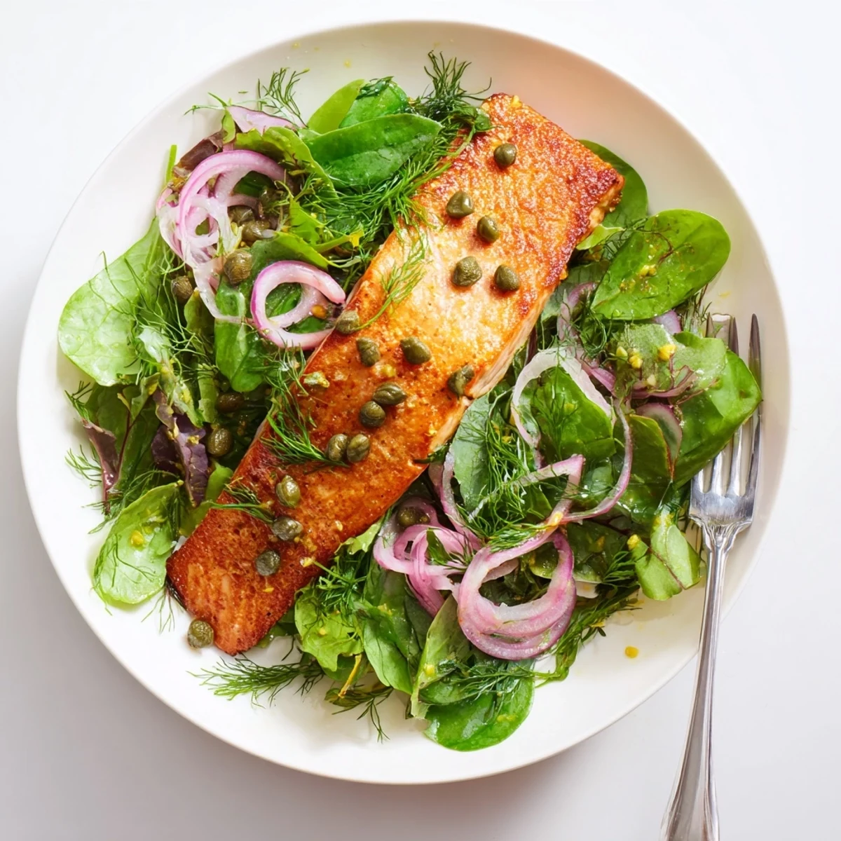 Close-up of Tasmanian Atlantic Salmon with crispy seared skin, lemon zest, and olive oil dressed greens.