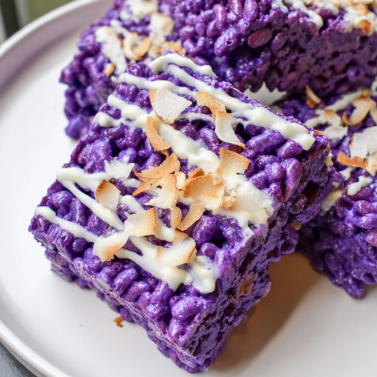 Purple ube rice krispie treats stacked on a wooden board with coconut flakes