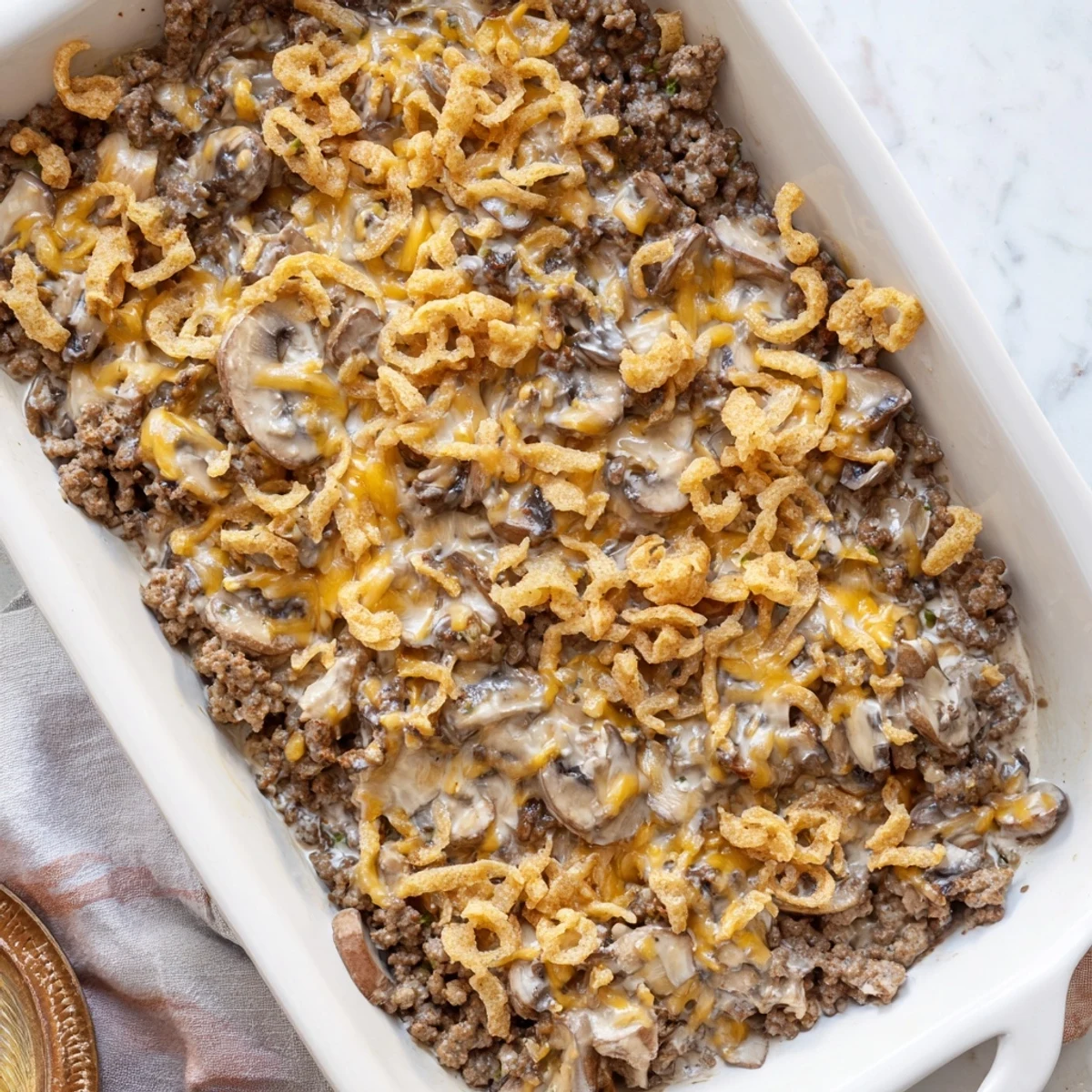 Hearty hamburger mushroom bake in a baking dish with golden buttery crumb topping