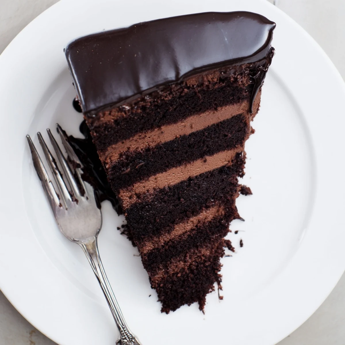 Decadent dark chocolate mousse cake showcasing moist sponge and silky mousse topped with glossy chocolate