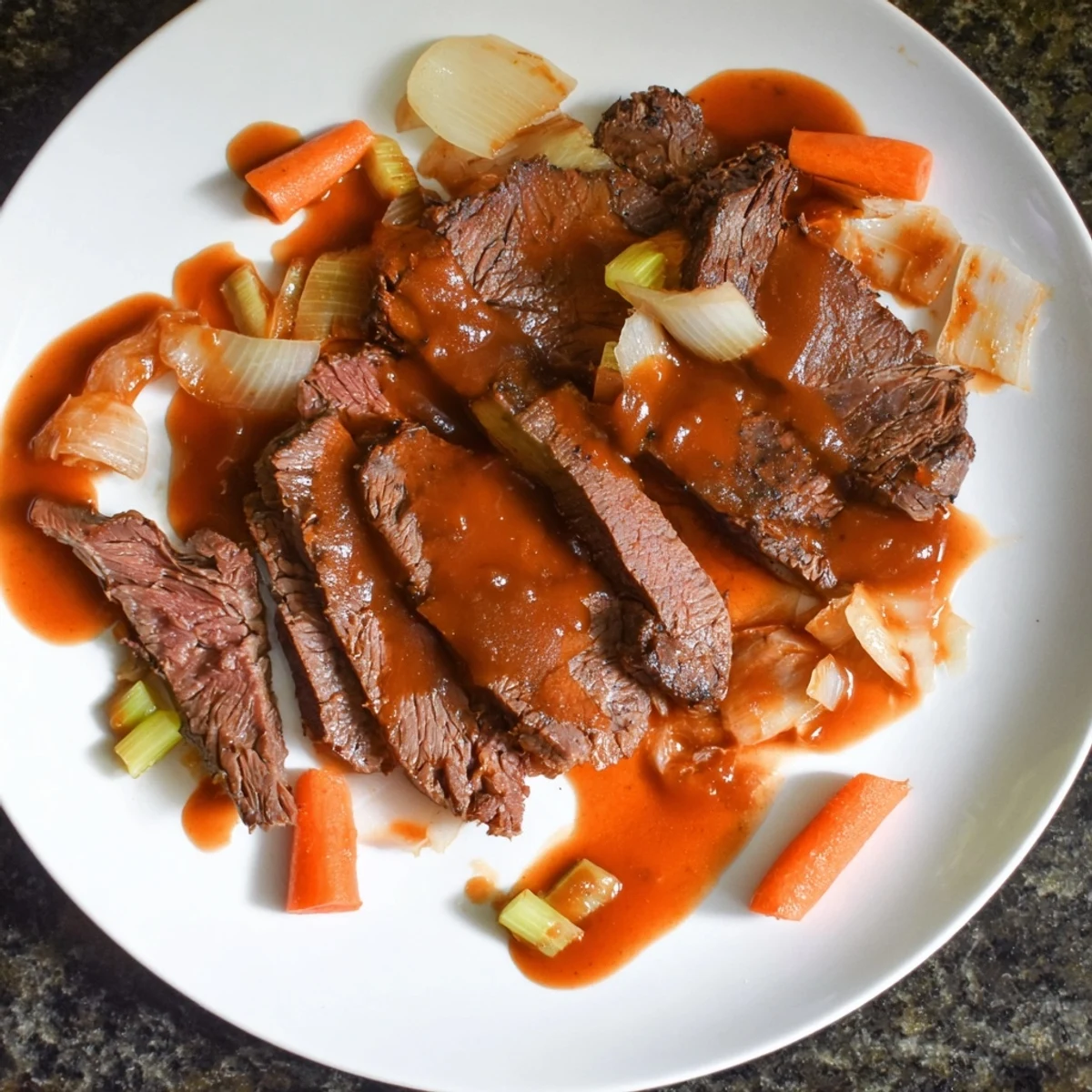 Tender slow cooker beef brisket slices resting on a platter with caramelized onions and roasted carrots