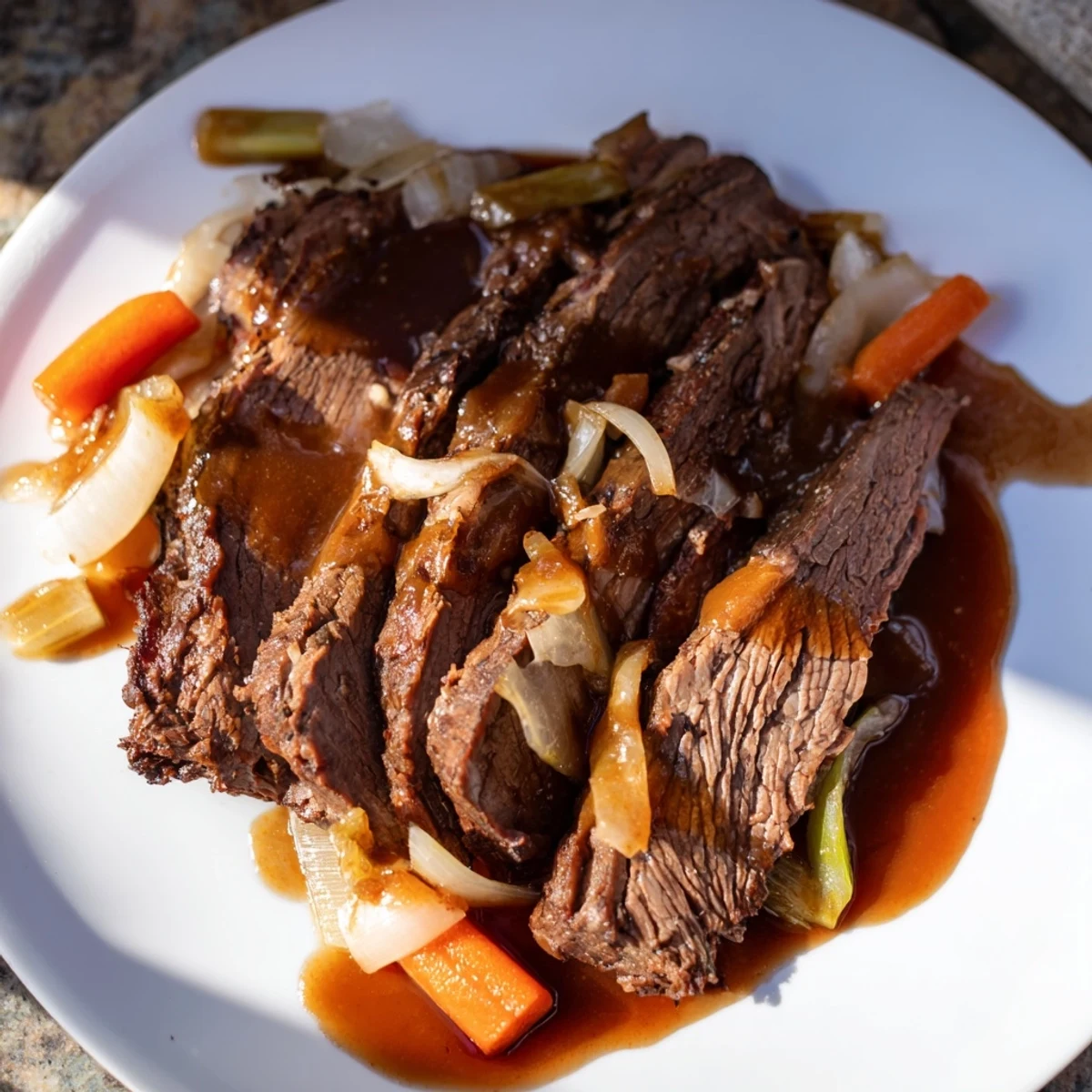 Sliced slow cooker beef brisket arranged on a serving plate with braised vegetables and glossy sauce