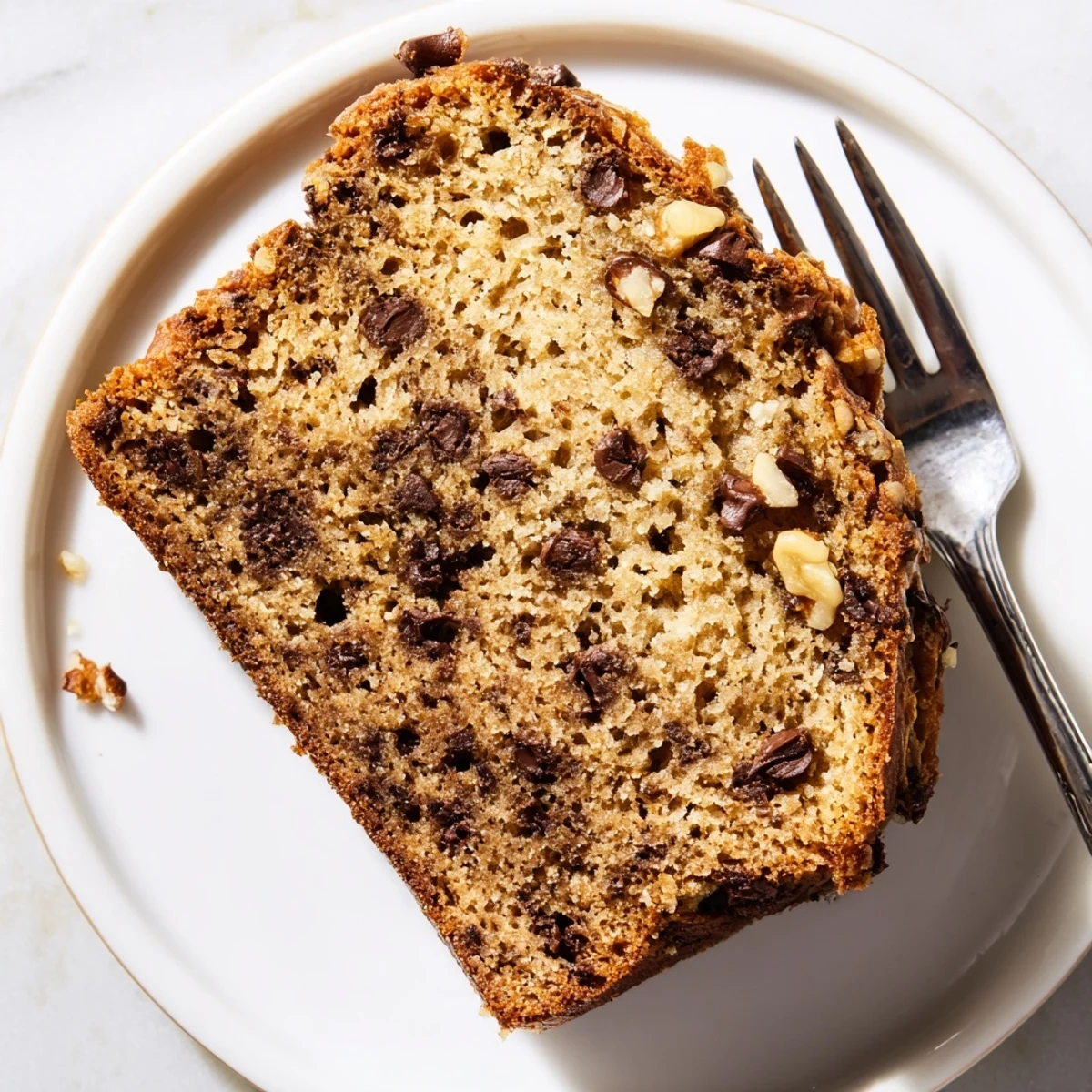 Freshly baked chocolate chip banana bread cooling on wire rack with cracked top