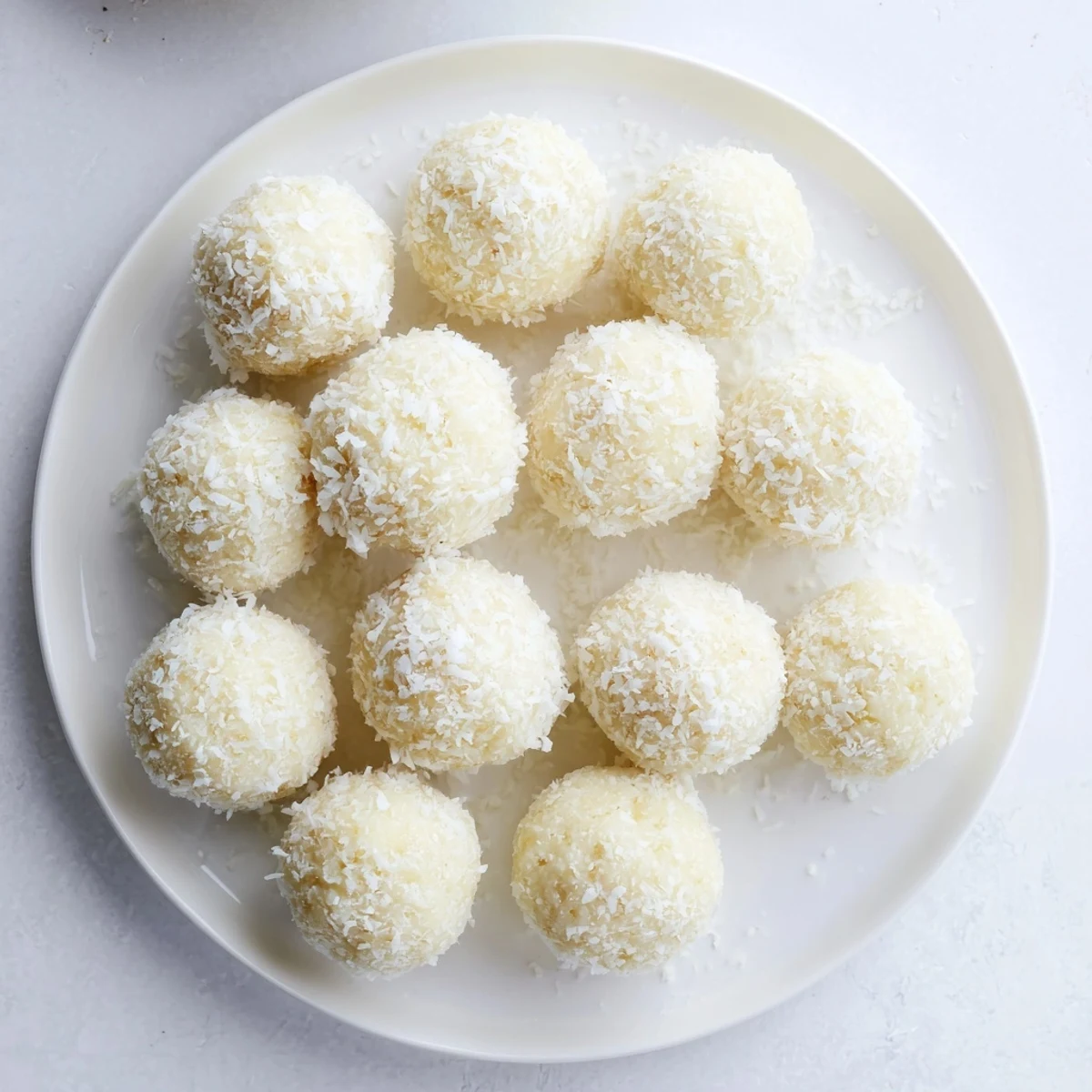 White no bake Easter bunny coconut tails coated in fluffy shredded coconut on a wooden board