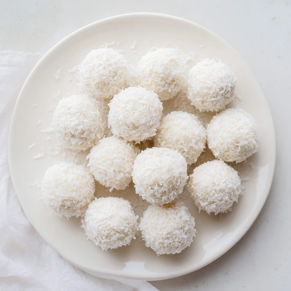 Bite-sized Easter bunny coconut tails with snowy white coating displayed on parchment paper for spring gatherings