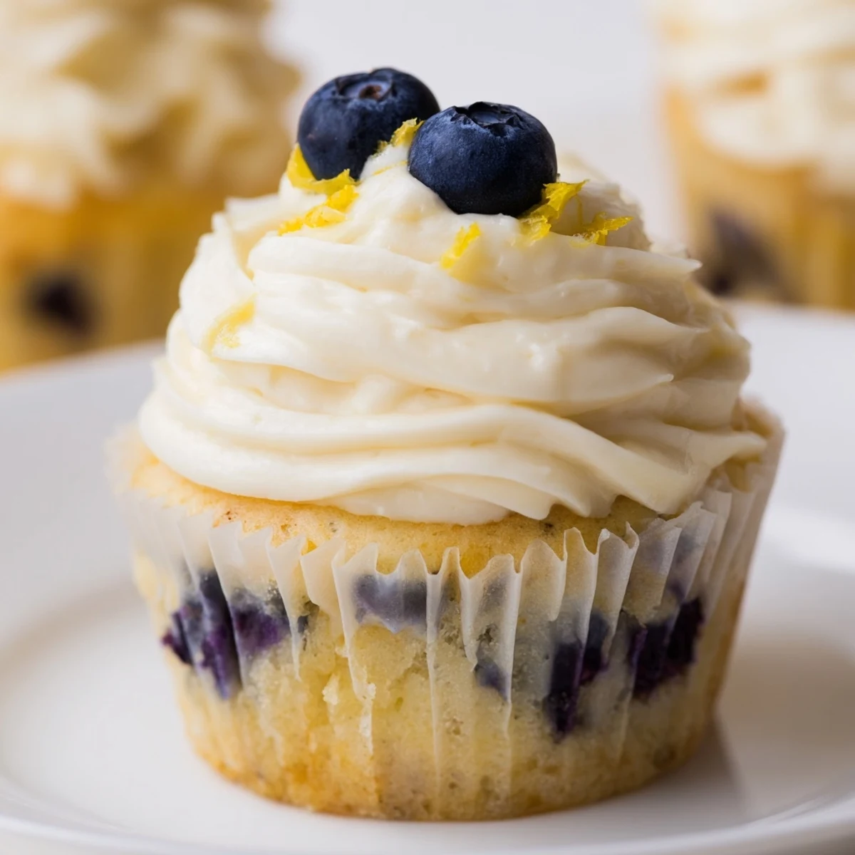 Fluffy lemon blueberry cupcakes topped with tangy cream cheese frosting and fresh berries