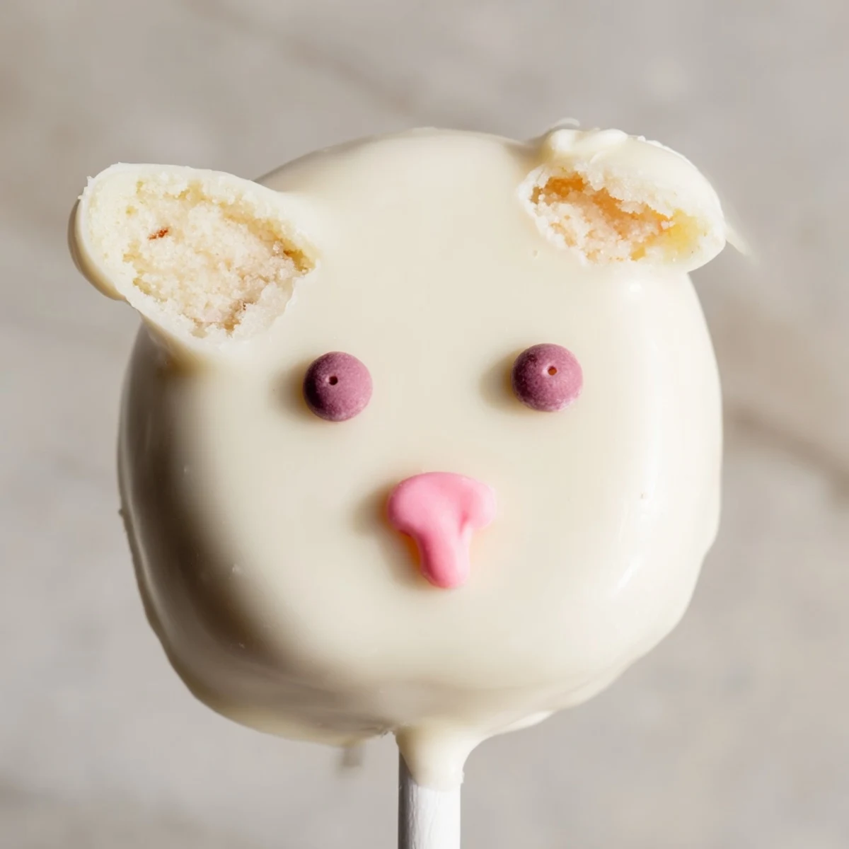 Adorable white chocolate bunny cakesicles with candy eyes and pink fondant ears on sticks