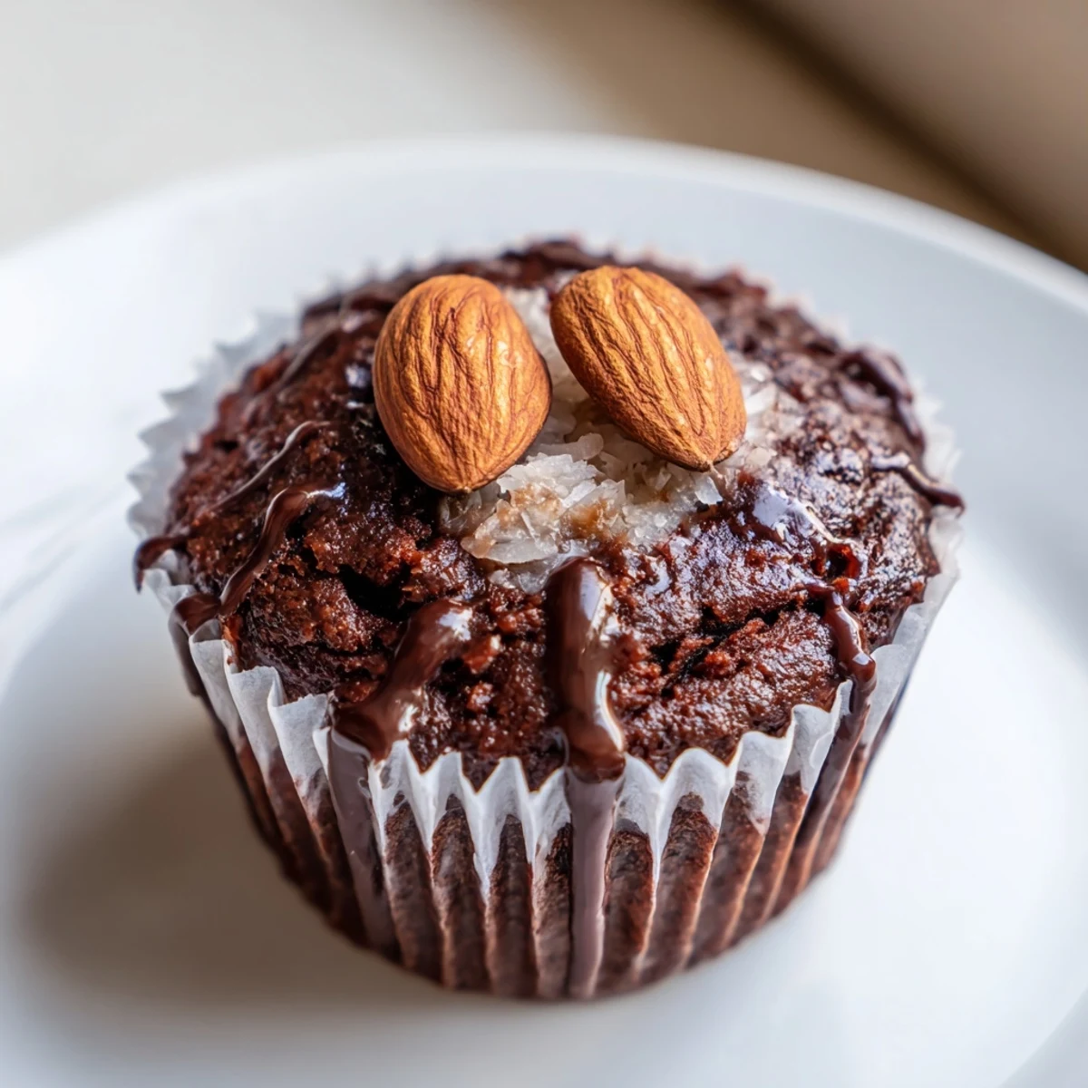 Decadent flourless almond joy cupcakes with gooey coconut centers dusted in dark cocoa powder