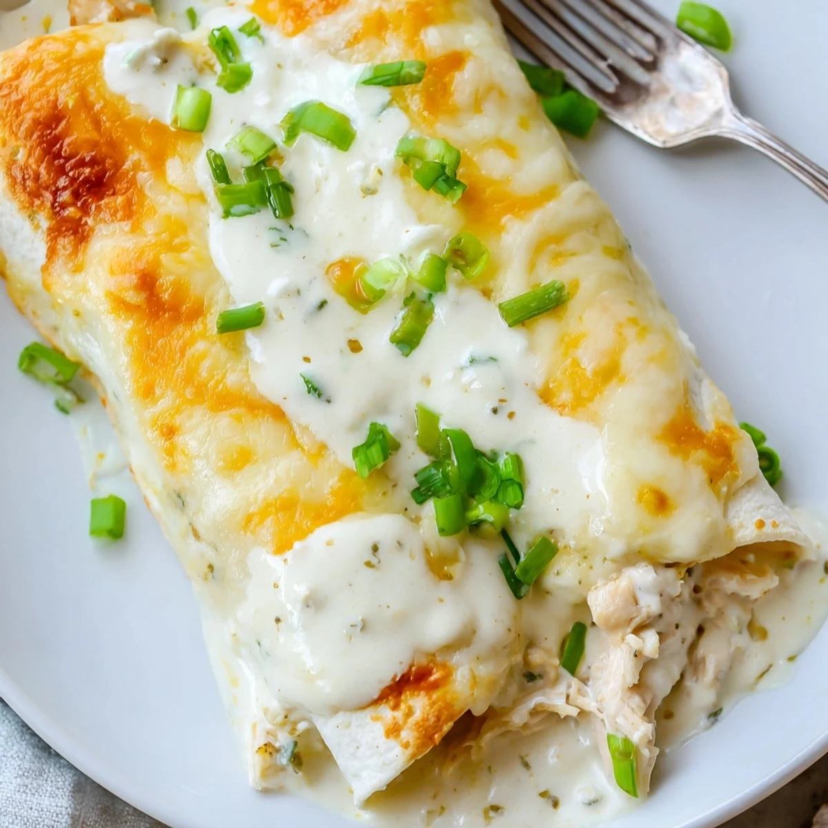 Warm Creamy White Chicken Enchiladas oozing velvety sauce, perfect for family dinners