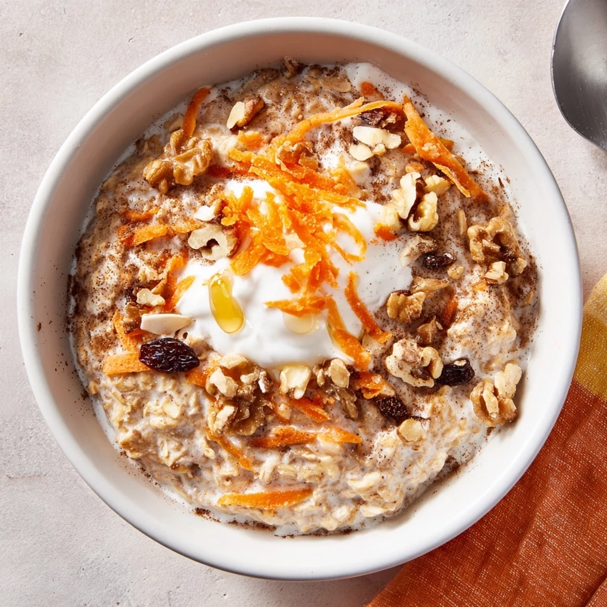 Morning ready Carrot Cake Overnight Oats stirred with Greek yogurt, raisins, warm spices