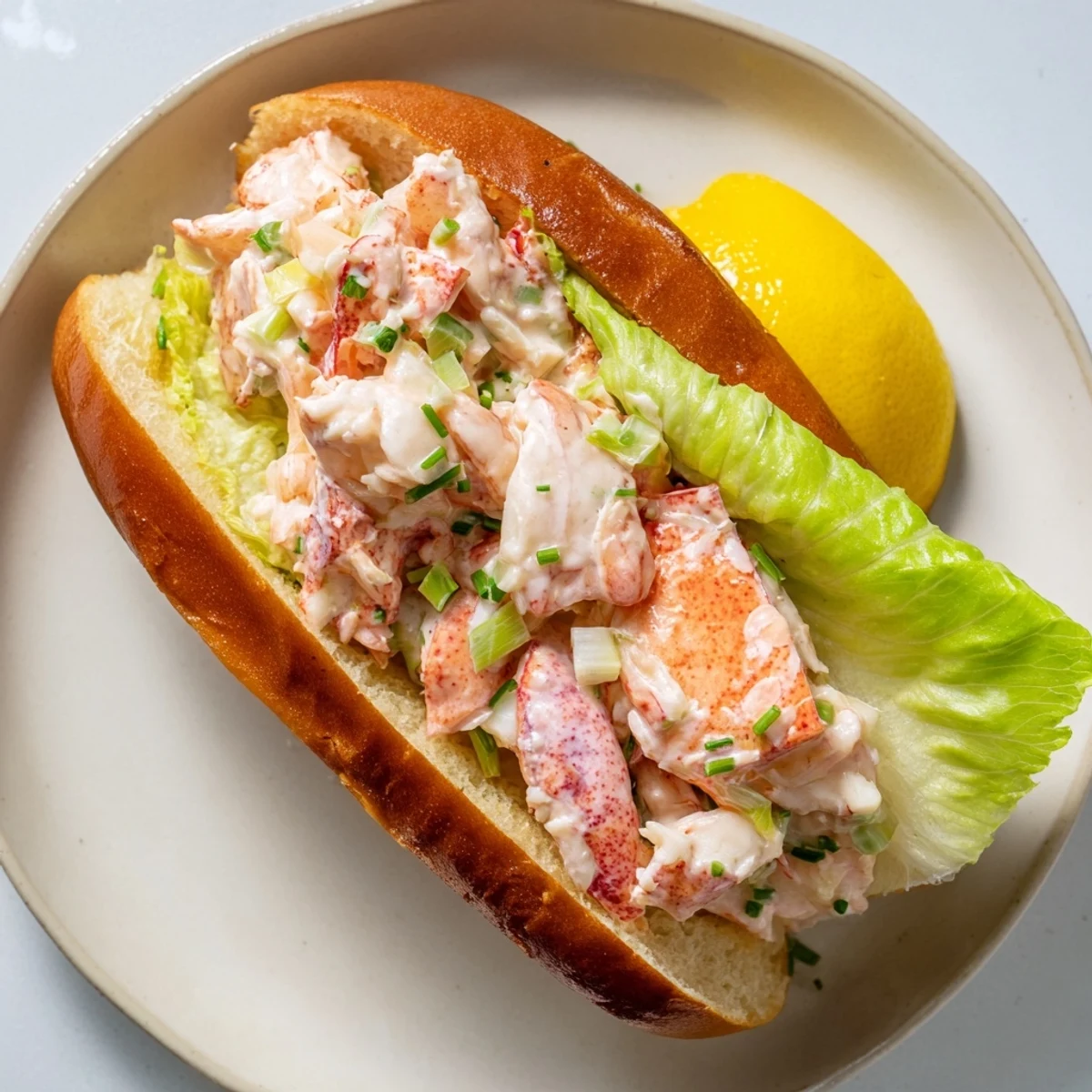 Fresh lobster salad tucked into butter grilled New England rolls with bright lemon and chive garnish