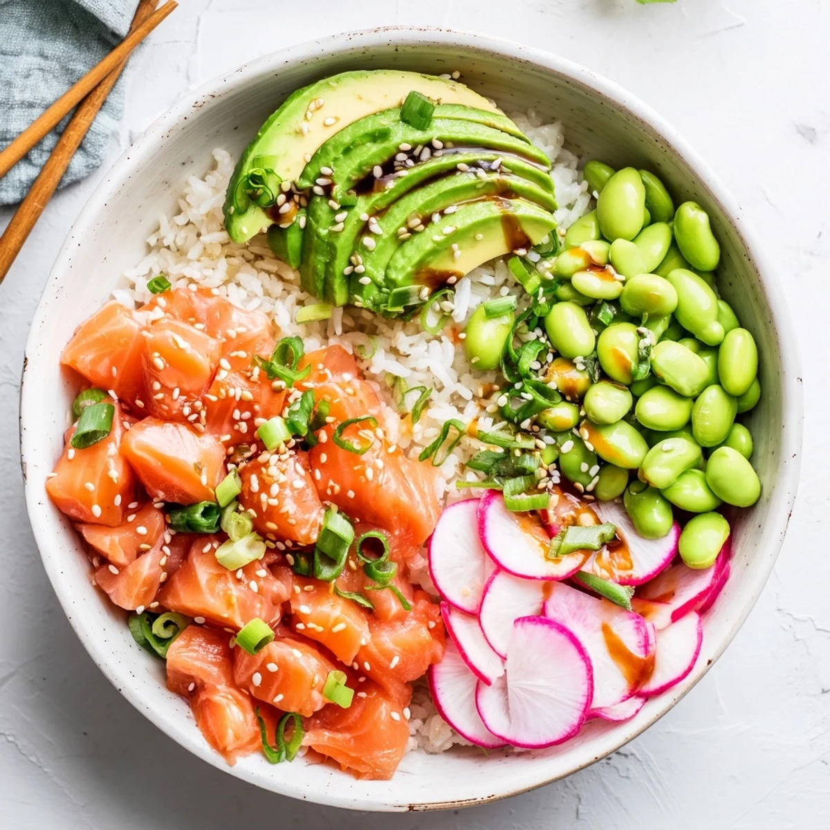 Colorful salmon and avocado poke bowl with fresh vegetables over seasoned sushi rice
