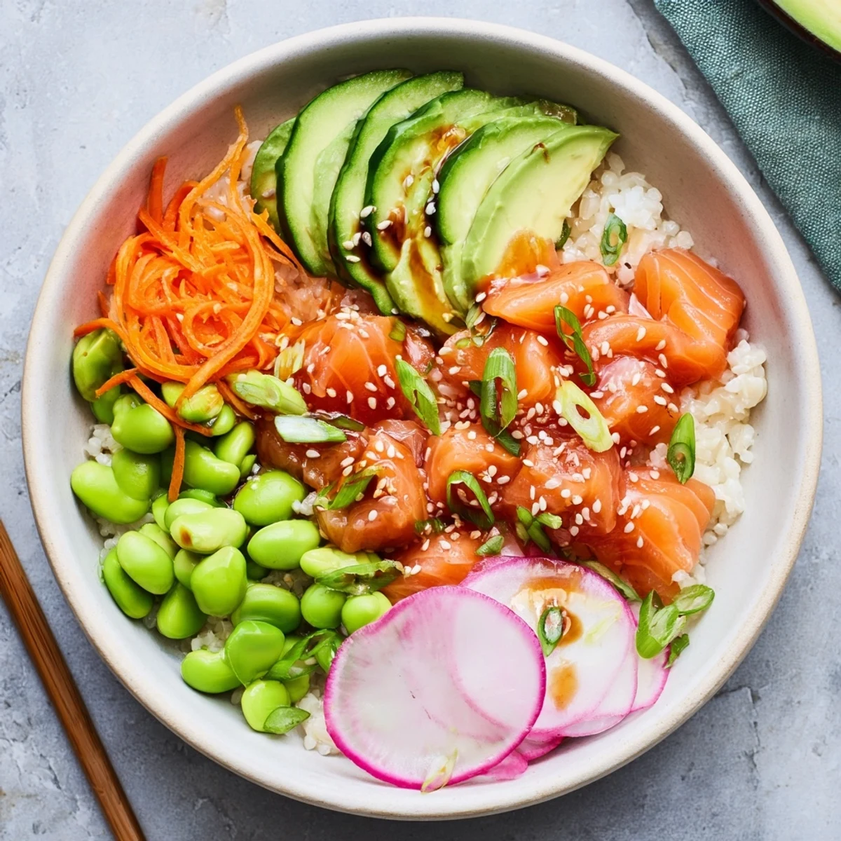 Fresh Hawaiian-style salmon and avocado poke bowl topped with crunchy vegetables and sesame seeds