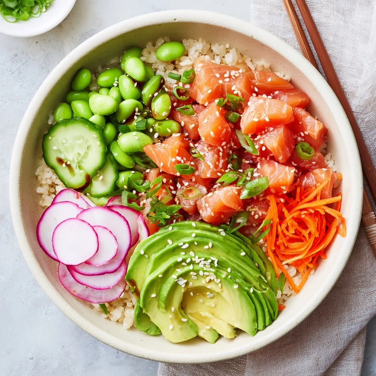 Healthy salmon and avocado poke bowl featuring marinated fish, crisp veggies, and savory sauce