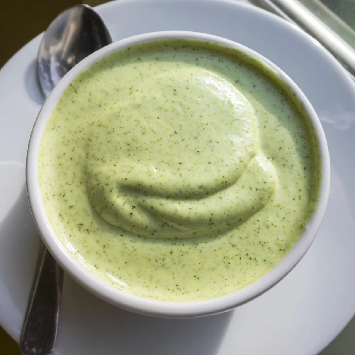 Smooth and tangy cilantro lime sauce garnished with extra fresh herbs for serving platter