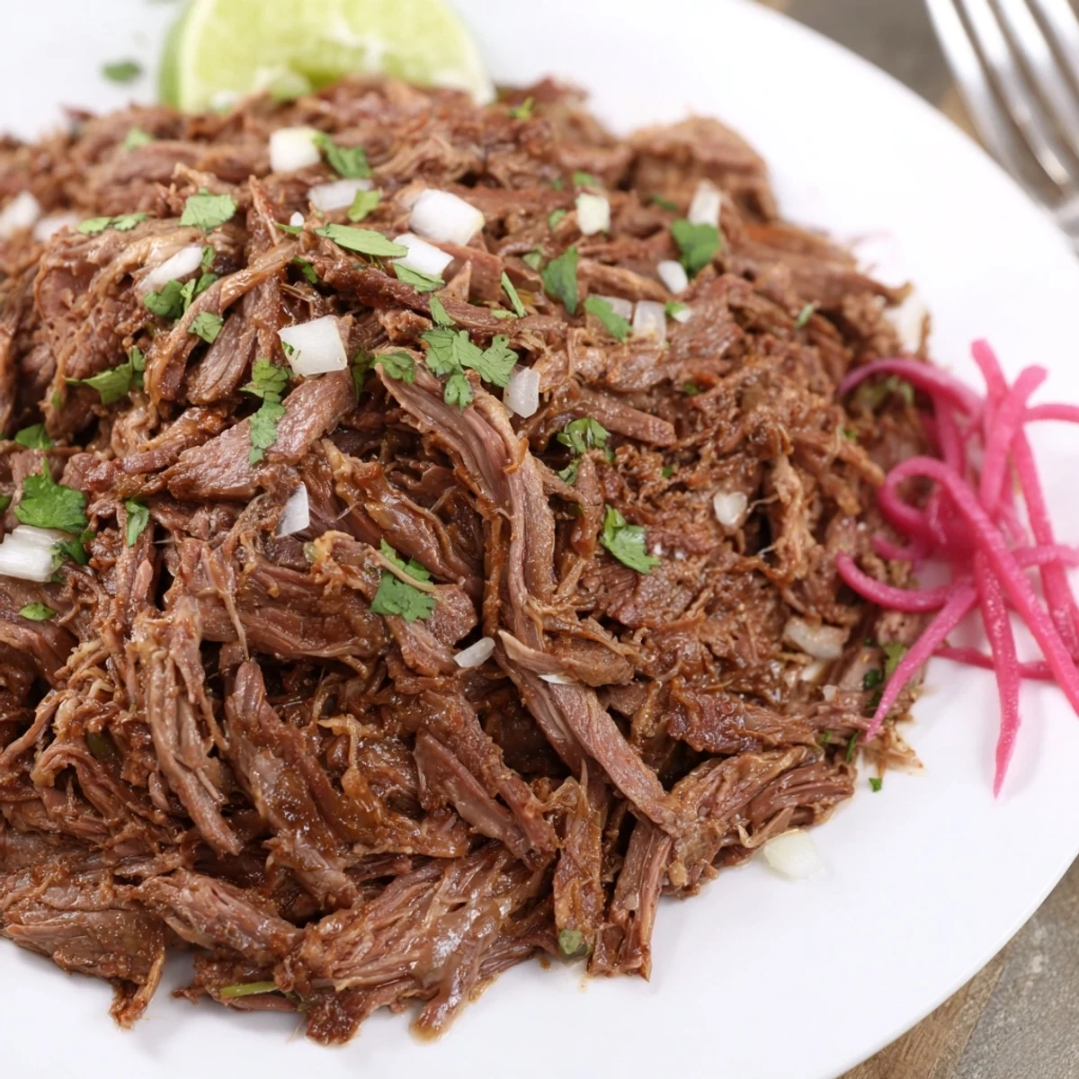 Fork-tender Slow Cooker Beef Barbacoa shredded in rich juices for tacos