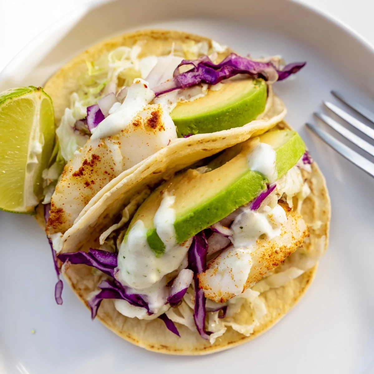 Baked Cod Fish Tacos with Creamy Cilantro Lime Sauce, flaky fish and slaw