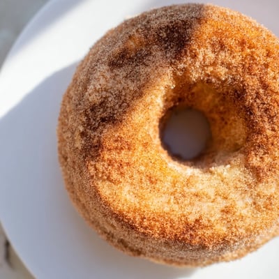 Twelve golden Delicious Baked Cinnamon Sugar Donuts You Can’t Resist rest on a wire rack for easy serving.  
